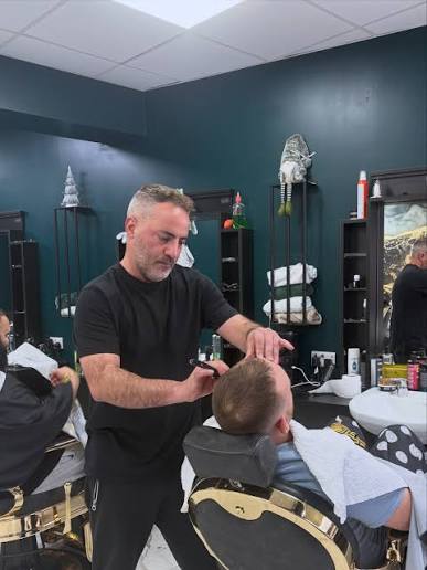 A barber finishing a cut at 24/7 Barbers